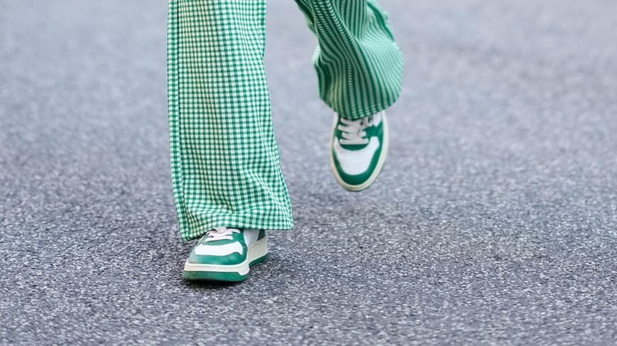 Dieser Trend-Sneaker von Rieker löst bei ü50-Frauen Herzklopfen aus Frau trägt Hosenanzug und grüne Sneaker