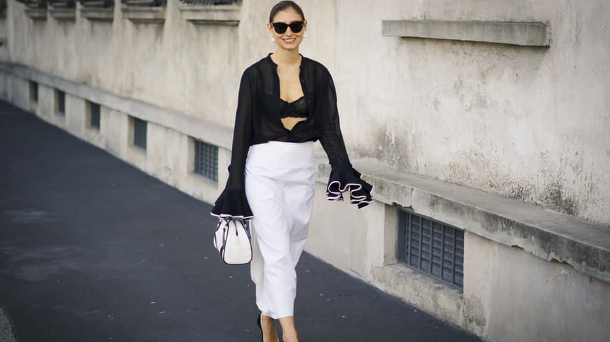 Kontrast-Core ist der edelste Modetrend im Sommer 2024 Frau trägt weißen Rock und schwarze Bluse