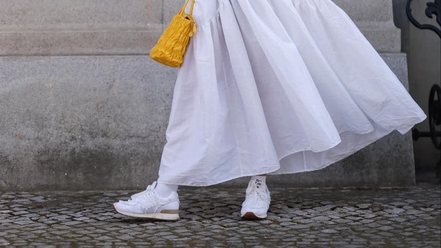 Sneakerzum Brautkleid Frau in weißen Kleid