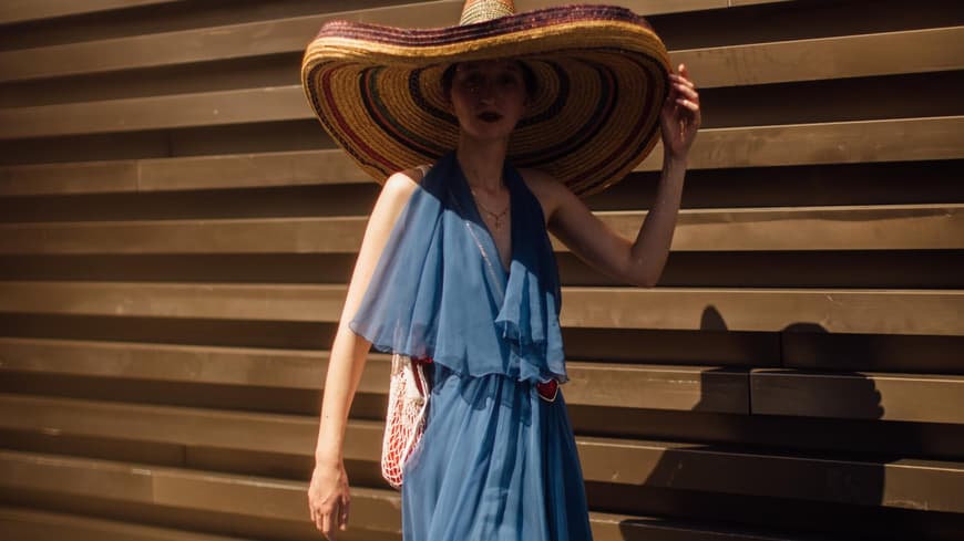 Frau mit blauem Kleid und Strandhut Frau mit blauem Kleid und Strandhut