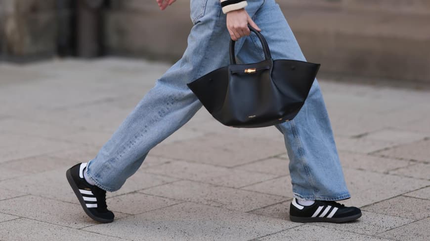 Weiße Sneaker sind out! Durch welche Trend-Modelle sie jetzt ersetzt werden Frau in schwarzen Sneakern