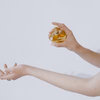 Bestes fruchtiges Parfum Frau sprüht sich mit Parfum ein