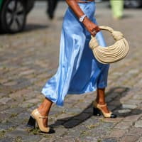 Frau trägt hellblauen Satinrock Frau trägt hellblauen Satinrock