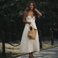 Bräunungsbeschleuniger sorgen schnell für einen sommerlichen Teint – unsere 4 Favoriten Frau in weißen Midi-Kleid