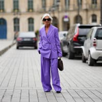 Frauen ab 60 Frau mit violettem Hosenanzug und grauen Haaren