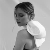 Das große Wochenhoroskop Frau trägt weiße Schleife um den Hals