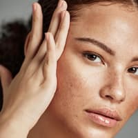 Faltenbehandlungen mit Hyaluron Frau schaut ihr Gesicht an