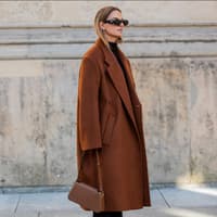 Wollmantel kombinieren Frau trägt braunen Wollmantel mit brauner Tasche