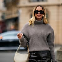 Frau mit Rollkragenpullover und Hoop Ohrringen Frau mit Rollkragenpullover und Hoop Ohrringen