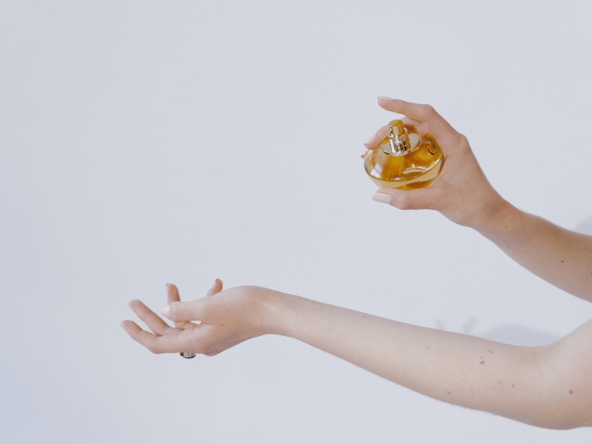 Bestes fruchtiges Parfum Frau sprüht sich mit Parfum ein