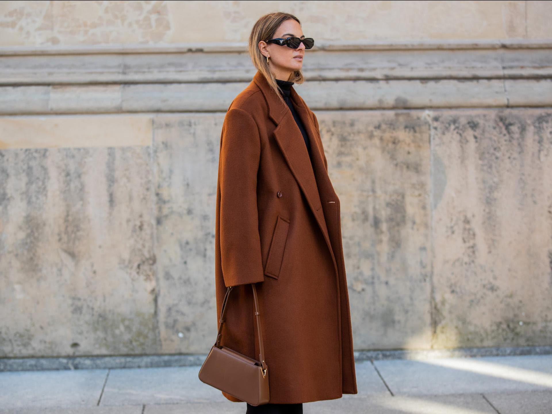 Wollmantel kombinieren Frau trägt braunen Wollmantel mit brauner Tasche