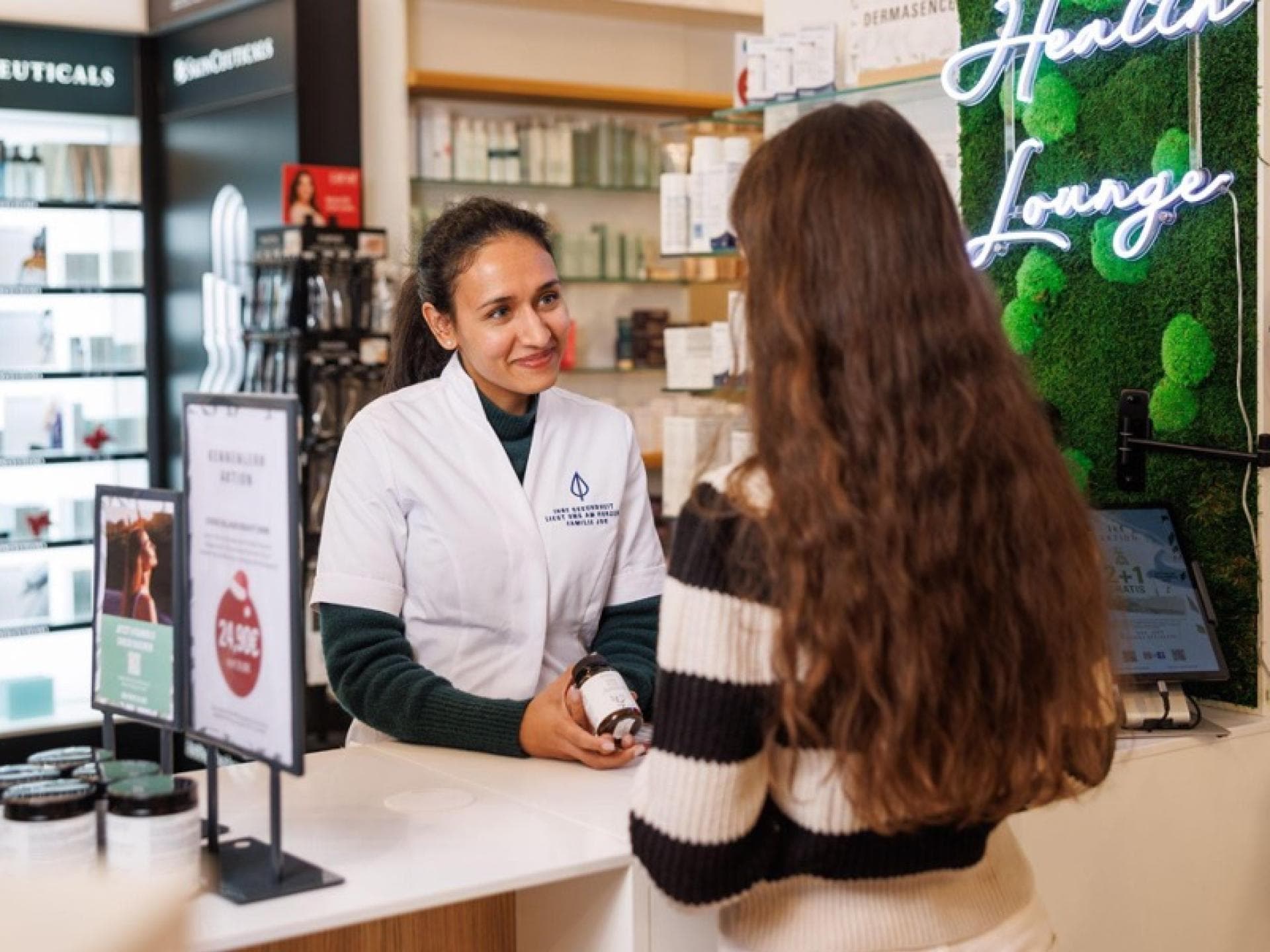 Eine junge Frau steht in der Apotheke