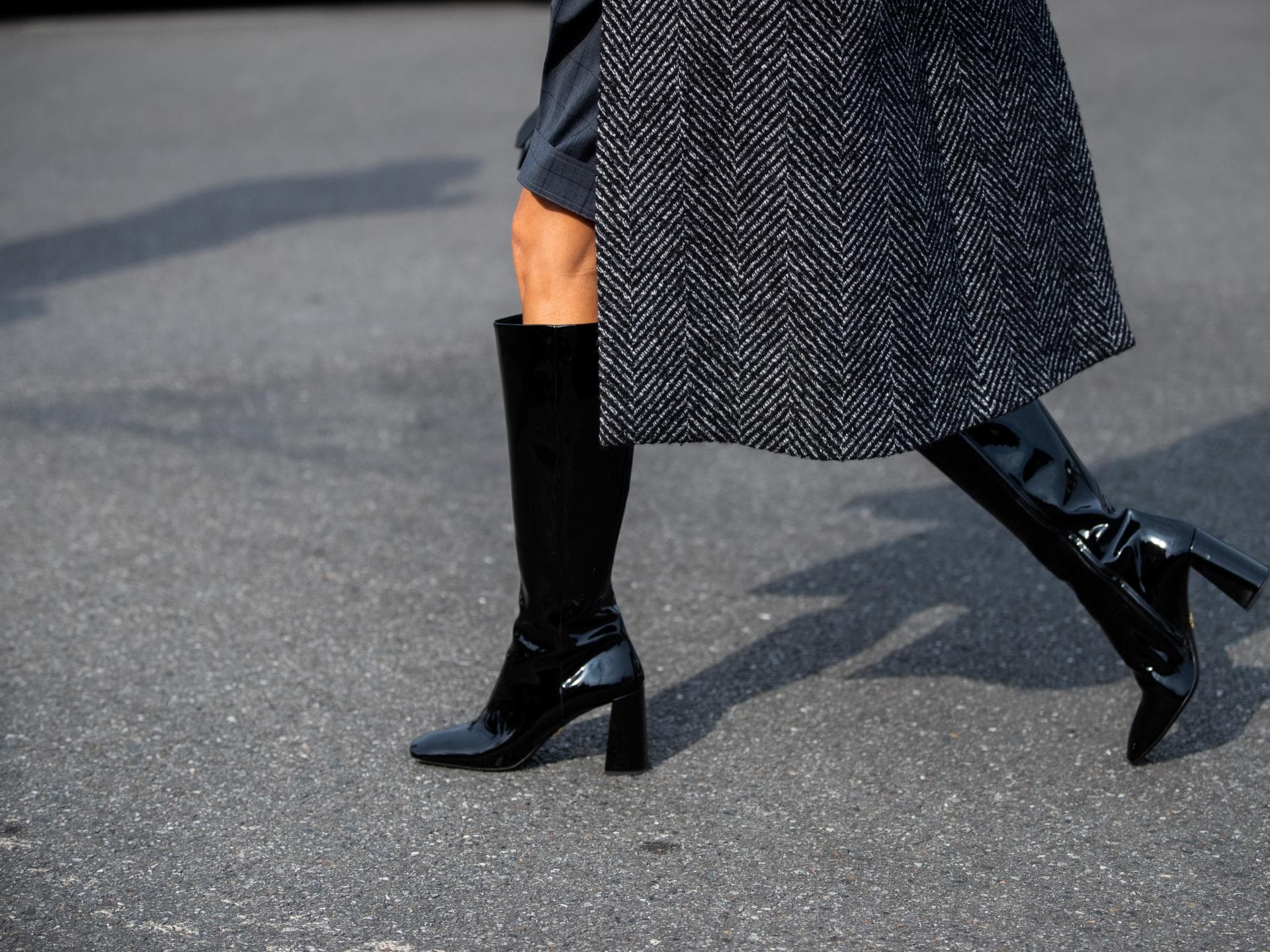 Stiefel-Trends Frau in schwarzen Stiefeln geht über die Straße